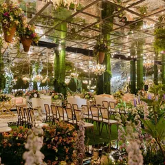 A signature transformation of an indoor ancestral space into a magical garden. We used a mirrored ceiling to reflect the dense population of plants, fresh flowers, and chandeliers, creating an enchanting atmosphere.