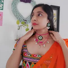 Here's how I styled this layered pink choker set for a Navratri look. It features a mirror work pendant, colorful beads, and cowrie shells, designed to complement a traditional embroidered blouse.