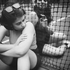 This portrait uses the tennis net as a framing device to create depth and story. It’s a pensive, moody shot that explores themes of separation and connection within the same frame.
