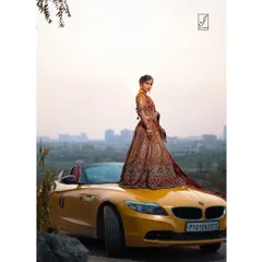 This wide shot captures the entire scene, blending the luxury of the car and the elegance of the traditional Indian attire with the natural landscape.