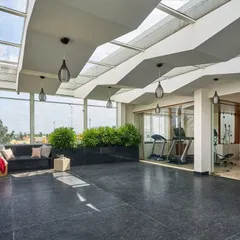 This wider view of the 'Wilasa' terrace shows the integration of a home gym behind glass walls. This keeps the space open and connected while dedicating an area for fitness.