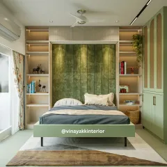 This master bedroom is all about symmetry and serenity. The plush olive-green headboard is flanked by built-in, back-lit bookshelves, providing both storage and soft, ambient light. The matching bed frame and wardrobe tie the whole look together.