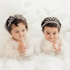 Two little princesses in a bed of clouds. We have experience with twin photoshoots, creating magical and coordinated portraits that celebrate their special bond.