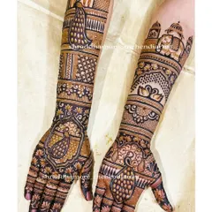 A stunning bridal design featuring multiple peacocks, swans, and a grand palace dome. The use of dark henna for filling creates a bold contrast that makes the motifs stand out.