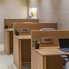 A close-up of the custom workstations, showing the clean lines, integrated power outlets, and the consistent wood laminate finish that ties the entire space together.