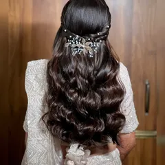 Another beautiful half-up hairstyle with soft waves, adorned with a different style of crystal accessory for a modern reception look.