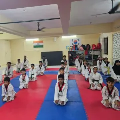 Students kneeling in formation during a belt exam. This moment reflects the discipline and respect that are central to Taekwondo.