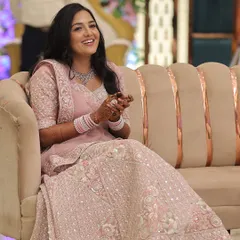 A full view of the pastel pink engagement lehenga and the complementary makeup. The look is cohesive, with a focus on glowing skin and a subtle lip that doesn't overpower the intricate outfit.