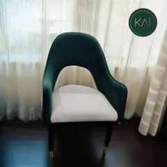 We crafted this statement chair with a dramatic open-back design, combining deep emerald velvet with a contrasting white seat. The tapered legs with brass tips add a final touch of luxury, making it a perfect accent piece for a high-end commercial lounge or a stylish home.