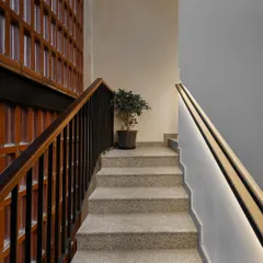 The main stairwell features a recessed, LED-lit handrail. This detail not only provides safe and subtle lighting but also makes the staircase feel more spacious and aesthetically clean.