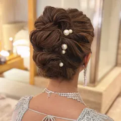 This is my signature "perfectly undone" look. I created this soft, textured messy bun to feel romantic and effortless, elevated with delicate pearl pins for a touch of class. It’s a versatile bridal updo that works beautifully for both the wedding ceremony and reception.