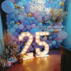 A gorgeous balloon wall in pastel blue, pink, and gold for a 25th birthday. The large marquee numbers and pampas grass accents give this photo backdrop a trendy and celebratory feel.