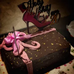 A fun and stylish cake for a 20th birthday celebration. This dark chocolate cake features a playful high-heel topper and a beautifully crafted pink bow, showing how I can match the cake to any party's theme.