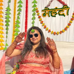 This guest is all smiles, posing with her full-hand mehendi at a vibrant party.