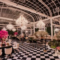 In this pre-wedding event, I transformed a modern glasshouse into a chic European conservatory. The striking black and white checkered floor contrasts with vibrant pink and lilac florals, while grand chandeliers add a touch of timeless glamour, creating an atmosphere of sophisticated romance.