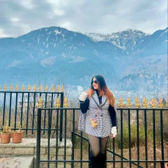 A full-length shot of my winter look in Manali. The snow-capped mountains provide the perfect backdrop for this stylish outfit.
