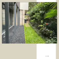 This narrow garden path combines a strip of green lawn with a bed of black gravel, separated by clean stone pavers. This design creates a visually interesting and low-maintenance solution for side yards and transitional spaces.