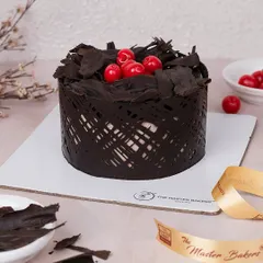 My take on the timeless Black Forest cake. It has layers of chocolate cake, whipped cream, and cherries, all wrapped in a modern chocolate lattice and topped with more chocolate shavings.