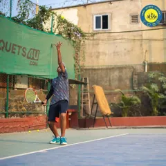 The toss and wind-up are crucial for a powerful serve. This action shot shows a player preparing to unleash an ace during a match on our hard court.
