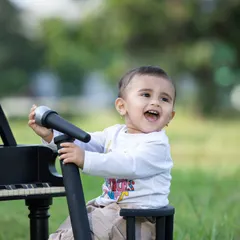 This future musician is enjoying an outdoor concert, with a mini piano and microphone set up in the park.