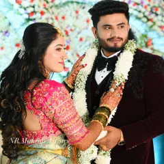 A candid moment during the reception. The bride's makeup is glowing and flawless, even up close, complementing her pink and silver lehenga.