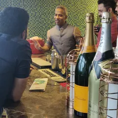 Engaging with guests is at the heart of what I do. Here, I'm discussing champagne options and cocktail preferences at a private party, ensuring everyone feels welcomed and gets a drink they truly enjoy.