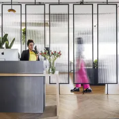 The reception area for LWYD Interactive, designed to make a strong first impression. We used fluted glass panels to create a sense of openness while maintaining privacy, balancing a modern aesthetic with a welcoming, human touch.