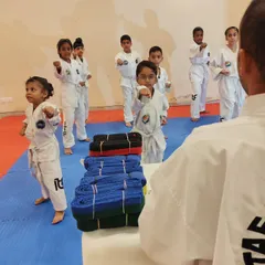 A group of our youngest students learns the basic ready stance, their eyes fixed on the instructor. Discipline and focus are taught from day one.