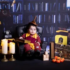 A little wizard in training. This six-month-old is exploring the magic of our Harry Potter set, complete with a sorting hat and a library backdrop.