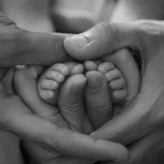 Ten tiny toes, held lovingly in their parents' hands. It's these small details that you'll want to remember forever. A classic newborn detail shot.