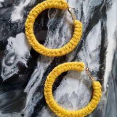A cheerful pair of macrame hoop earrings in a sunny yellow, perfect for brightening up your day.