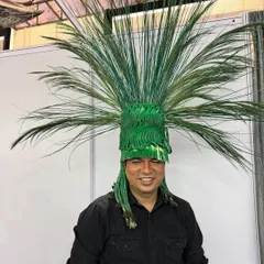 A close-up of one of the incredible, nature-inspired headpieces from our show. This piece was crafted to look like a vibrant, exploding palm, showcasing hair as a sculptural medium.