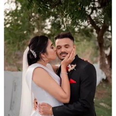 A sweet and candid moment after the ceremony, with the bride planting a happy kiss on her groom's cheek.