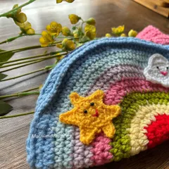 A close-up of our mini crochet rainbow bag for kids. The little star and cloud details are all hand-stitched, making it extra special.