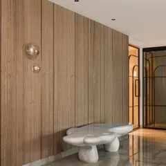 This entrance foyer is an exercise in warm minimalism. We used soft textures like the fluted wood wall paneling and a sculptural stone-like bench to create a calm, grounded feeling. The bubble-like wall lights add a touch of playful elegance.
