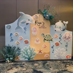 A sweet and gentle underwater theme for Rian's first birthday. This custom backdrop features adorable illustrations of a dolphin, whale, turtle, and other friendly sea creatures.