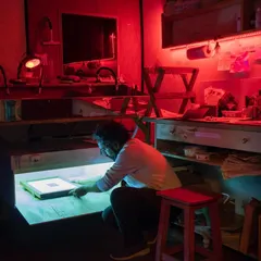 Here is a look inside our dedicated darkroom, illuminated by the glow of the UV lightbox. This space is the heart of our alternative photography offerings, fully equipped for processes like cyanotype, Vandyke brown, and gum bichromate printing.