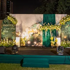 A full view of the main stage setup for the Inditex party at night. The combination of the printed backdrop, dramatic lighting, and floral decor created a captivating focal point for the evening.