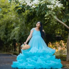 A solo portrait of the mother-to-be. The light blue gown, paired with a simple basket of flowers and soft makeup, creates a look of pure serenity and joy.