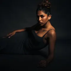 A low-angle shot with dramatic, low-key lighting. The shadows create a mysterious and cinematic mood, perfect for an artistic portrait.