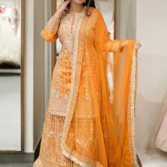 An outfit that brings its own glow. This beautiful orange sharara set with intricate silver embroidery is perfect for a Haldi or Mehendi ceremony.