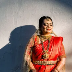 Bathed in golden light, our bride looks absolutely divine. This shot beautifully captures the antique finish of her full temple jewellery set, including the intricate vaddanam (waist belt) and maang tikka.