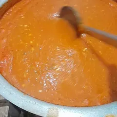 A large pot of my signature pizza sauce, simmering with fresh tomatoes, garlic, and herbs. I never use store-bought sauces for my pizzas.