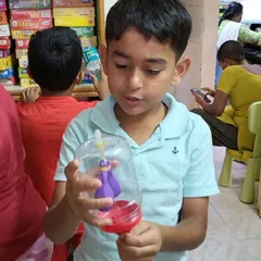 A young student proudly displays the model of human lungs he built. Using a bottle and balloons, we demonstrate how the diaphragm works, making biology interactive and easy to grasp.