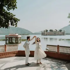 A joyful, candid moment of a couple dancing with the iconic Jal Mahal in Jaipur as their backdrop. This image captures the fun and spontaneity we encourage during our royal pre-wedding shoots.