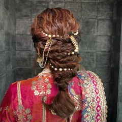 A hairstyle should be a work of art. This intricate textured braid, woven with delicate pearl accessories, was designed to be both beautiful from all angles and sturdy enough to last through a full day of celebrations.