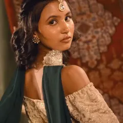 A profile view of the Heeramandi-inspired look, showcasing the elegant hairstyle and the client's graceful posture.