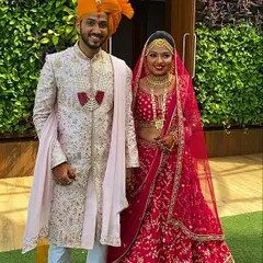 This groom is wearing a custom baby pink sherwani made from raw silk fabric. The entire piece features all-over hand and machine work and is styled with a georgette dupatta for a soft, elegant look.