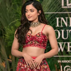 National crush Rashmika Mandanna looking radiant in a red embroidered lehenga. A beautiful portrait capturing her grace and charm at a fashion event.