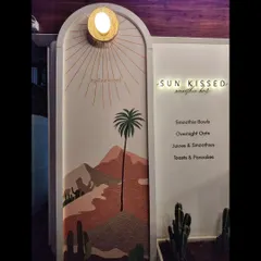 The mural at night, with the cafe's sign and lighting creating a warm and welcoming glow.